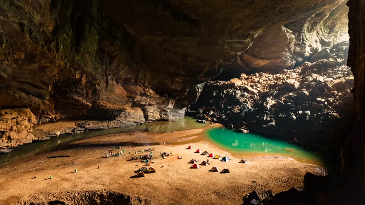 Massive chamber inside Hang Son Doong, the world's largest known cave passage, with a jungle and river