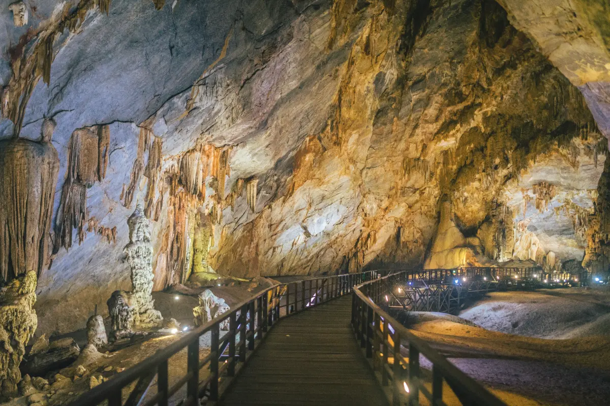 Wooden boardwalk inside Paradise Cave in Phong Nha, passing towering stalactites and stalagmites
