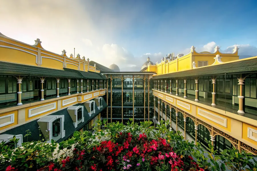 Indochine-style hotel interiors with shuttered windows, tiled floors, cane furniture and ceiling fans
